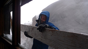 営業終了後下山前に雪囲いを設置する三橋さん